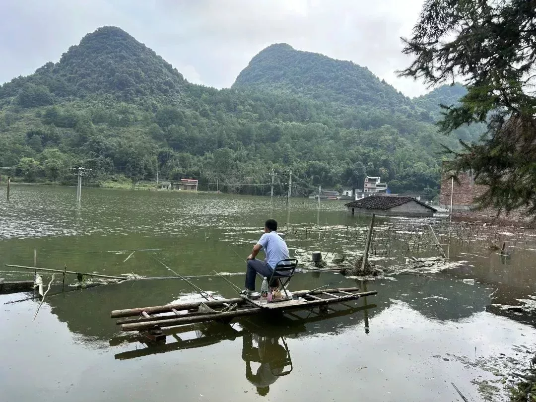 ▲ 2024年8月30日,廣西六安村,村民在積水邊釣魚。